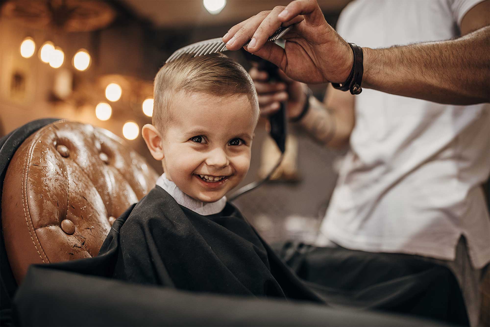 Barn som får sitt hår klippt på frisörsalong