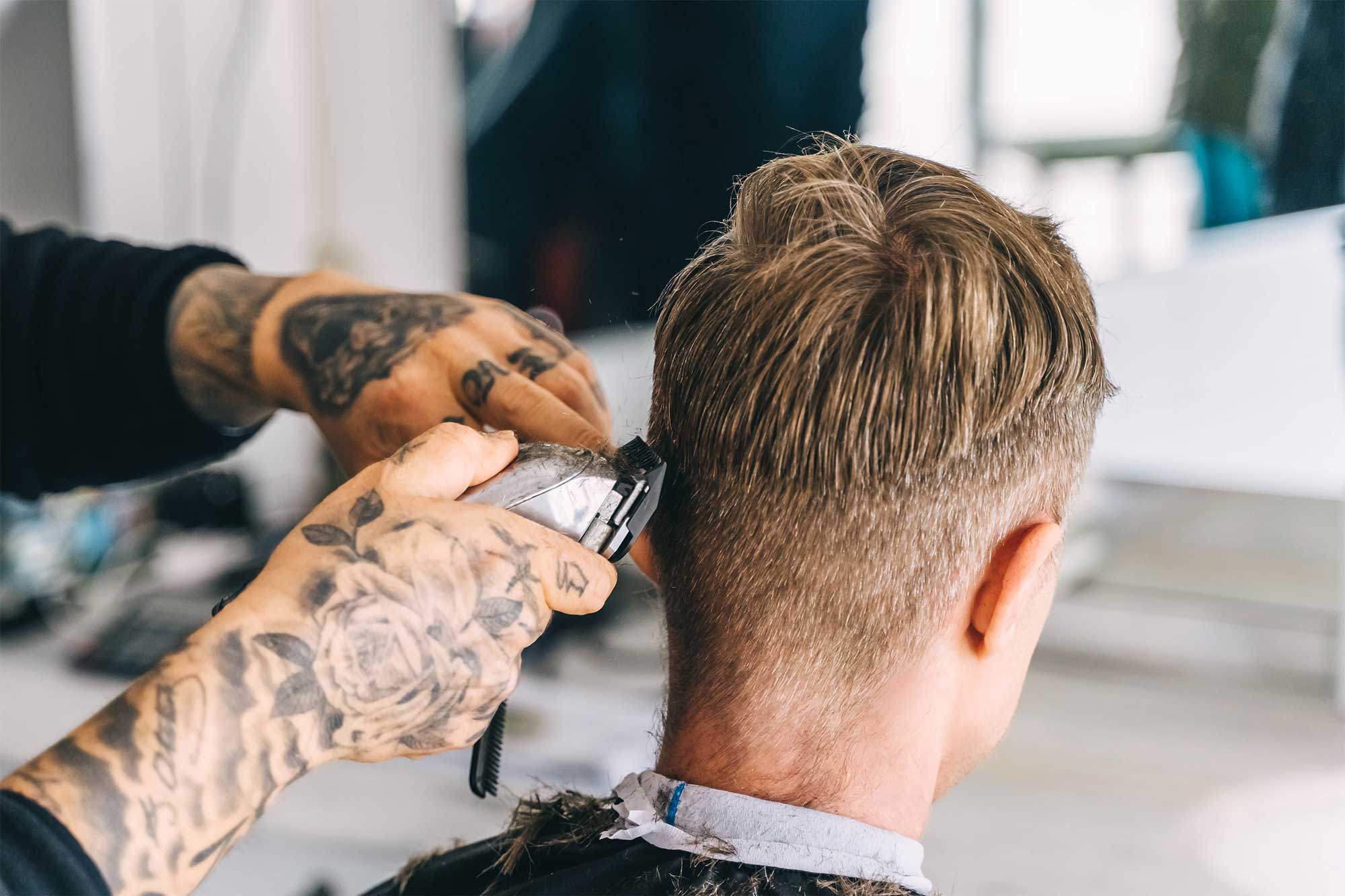 Kund som får sitt hår klippt av frisör