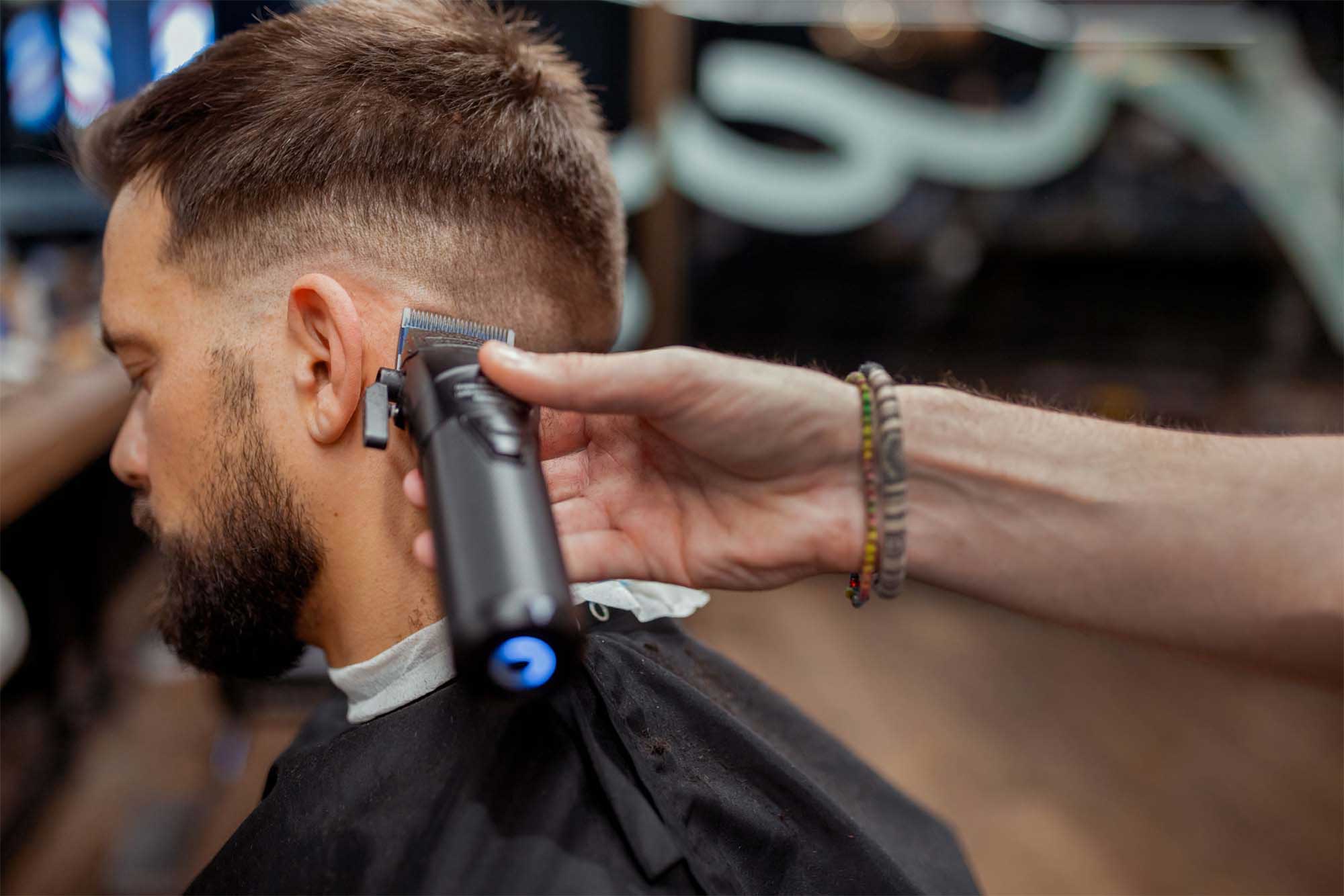 Person som får sitt hår klippt med maskin på salong